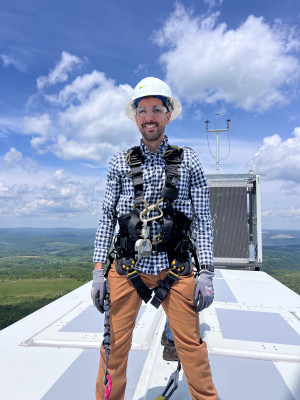 John on a work trip exploring the top of a wind turbine